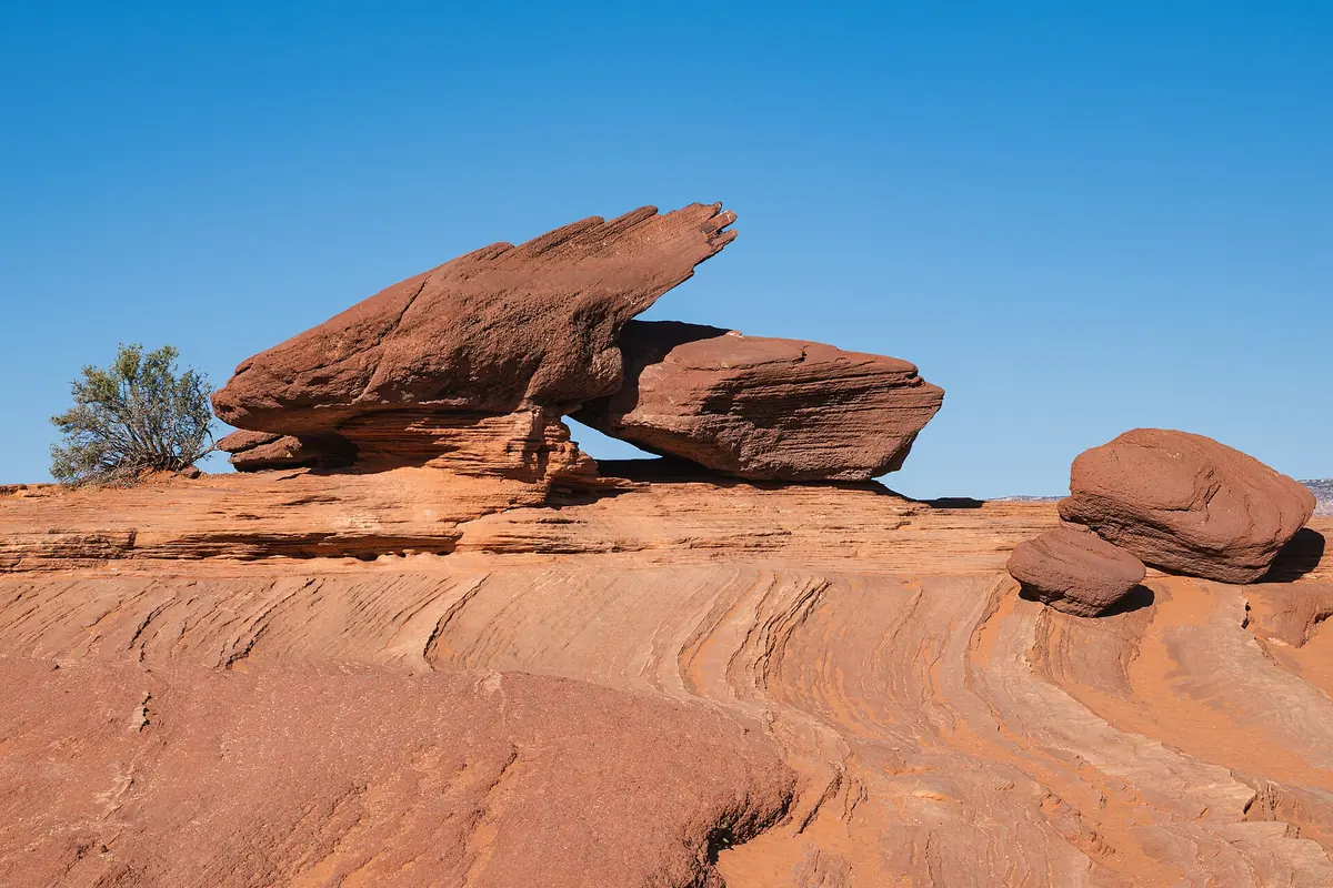 Cross-bedded red sandstone with two weathered boulders at the Horseshoe Bend overlook.